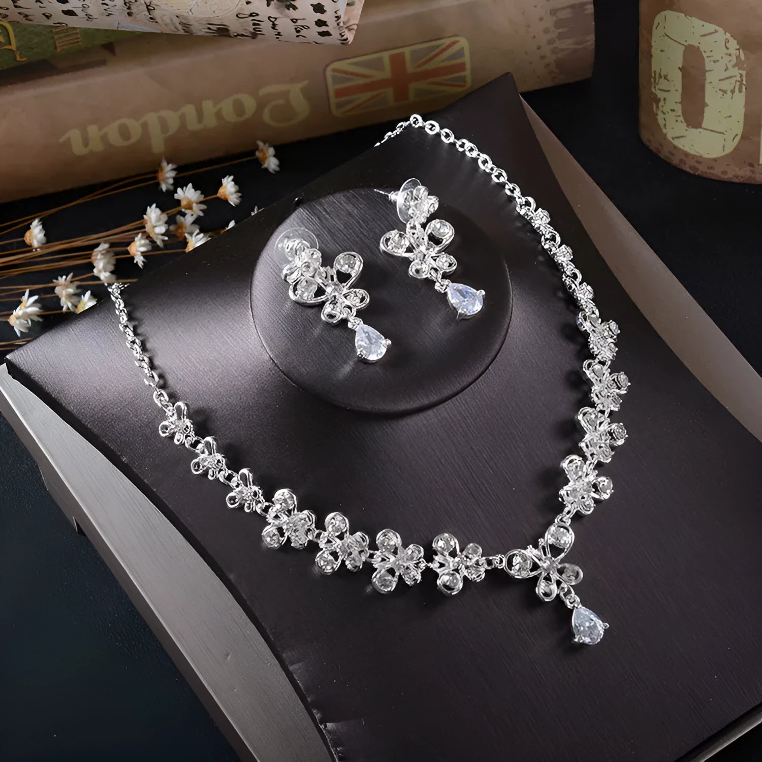 White rhinestone butterfly pendant necklace and matching pierced drop earrings set on white background