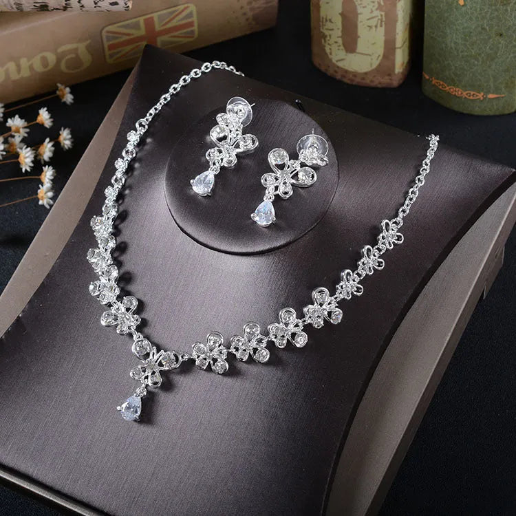 White rhinestone butterfly pendant necklace and matching pierced drop earrings set on white background