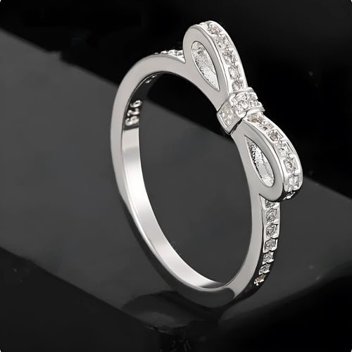 Silver electroplated ring with a detailed bow shape and set zircon crystal accents.