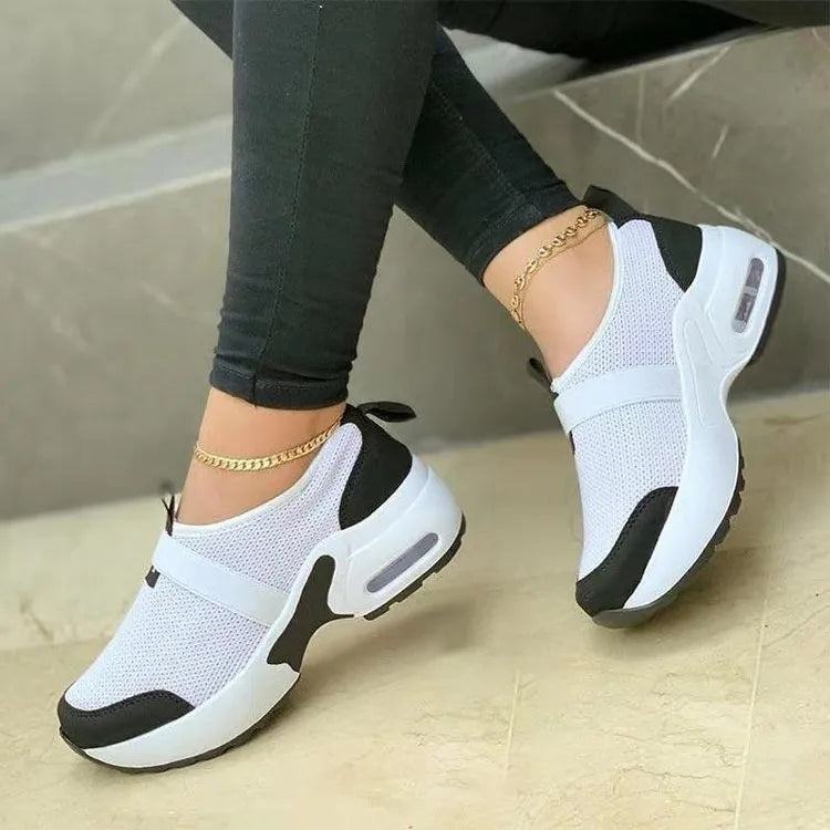 Women's white mesh flat sneakers with round toe and colour stitching on a rubber sole.