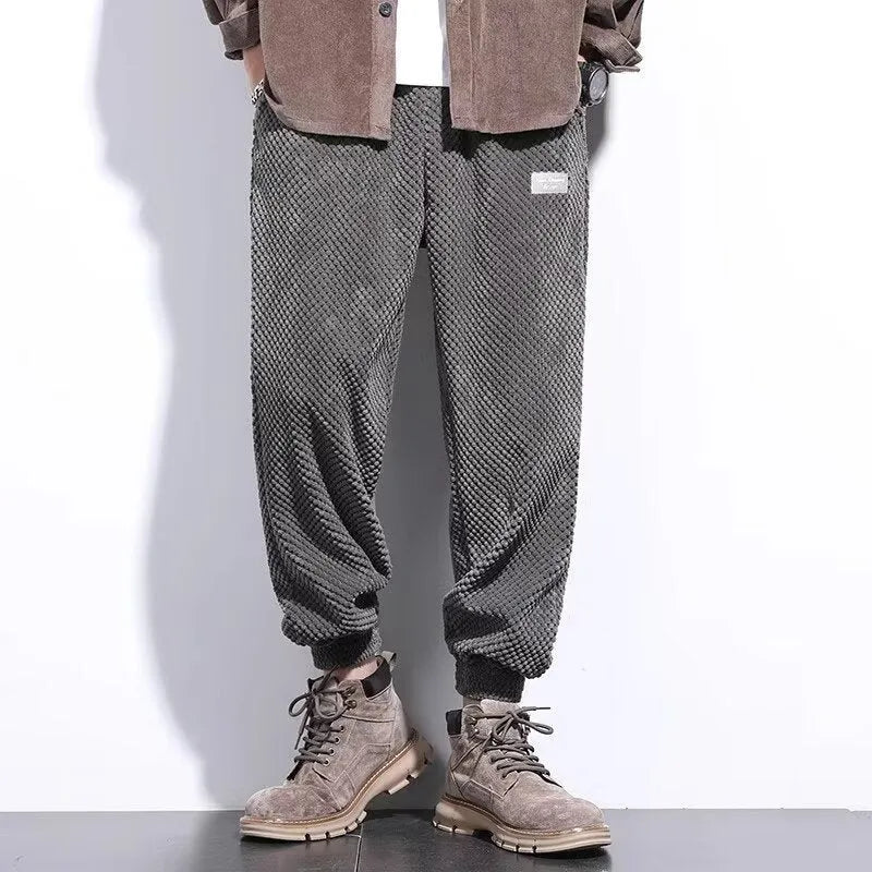Men's grey ankle-tied straight-leg sweatpants laid flat, showing the tapered cut and tie detail.