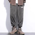 Men's grey ankle-tied straight-leg sweatpants laid flat, showing the tapered cut and tie detail.