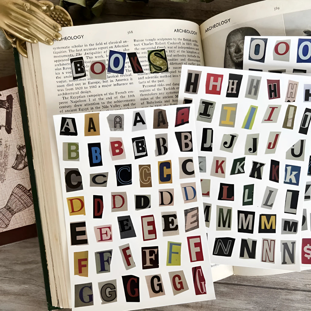 Set of printed cute-style stickers showing English letters A, B, C, D, E, numbers, symbols, and weekly words on a sheet.