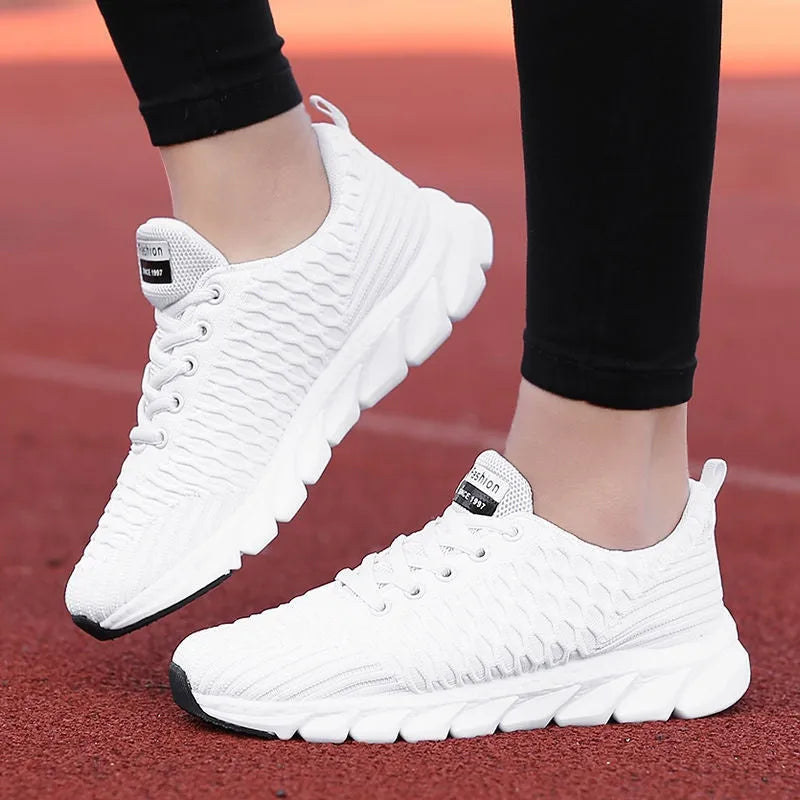 Women's black running shoe with fly weave upper and textured wear-resistant outsole.