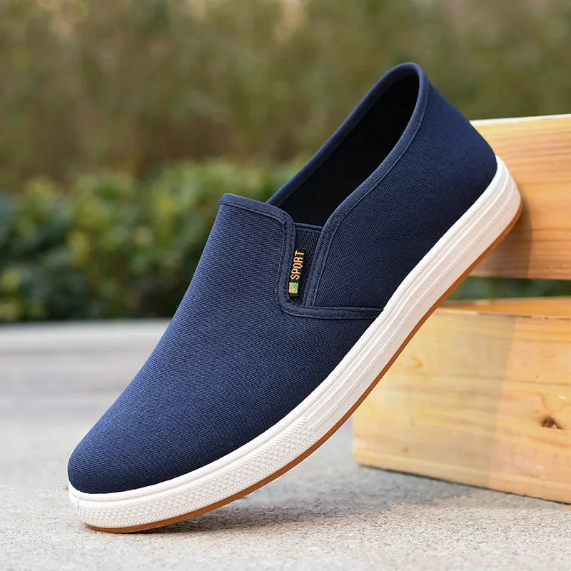 Men's black and blue slip-on canvas shoes with composite soles showing round toe design