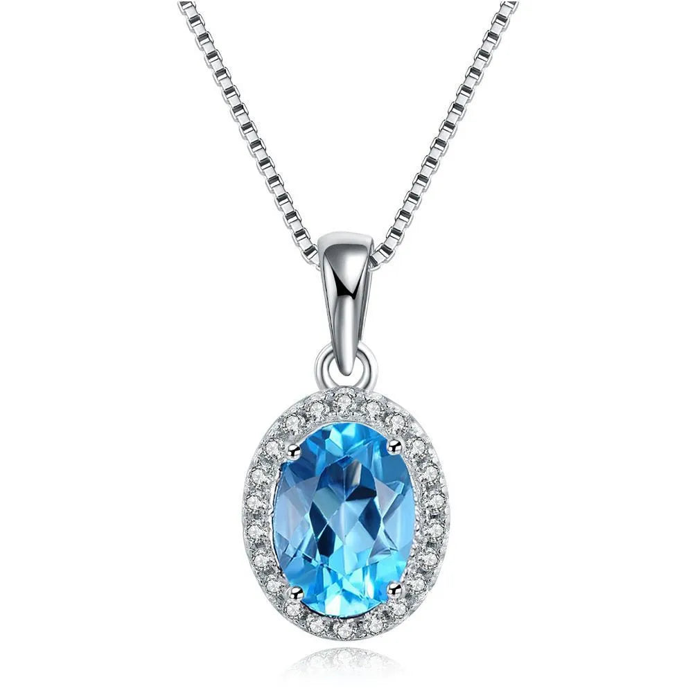 Women's 925 silver blue topaz jewellery set showing geometric earrings, ring, pendant and necklace.