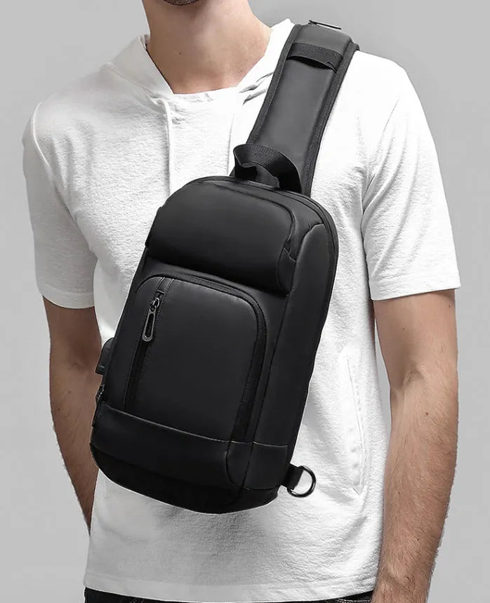 Black medium-sized PVC outdoor shoulder bag with a single strap and internal organiser pockets.