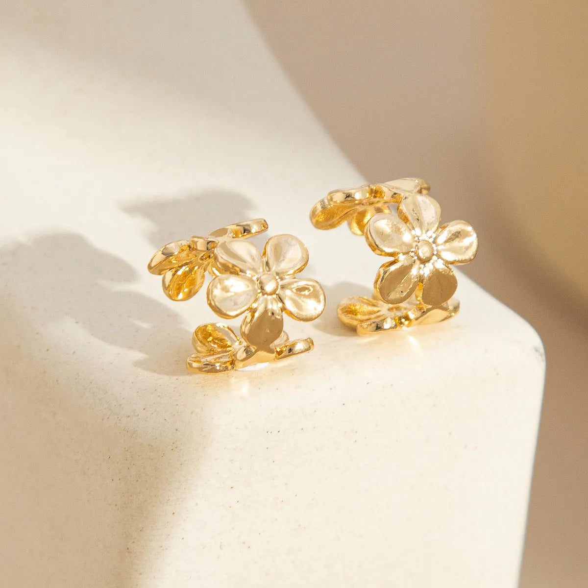 Gold-coloured starfish and scallop shell dangle earrings for women on a white background.
