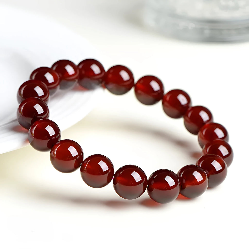 Natural orange red garnet ball crystal bracelet with traditional ruyi design elements on wrist
