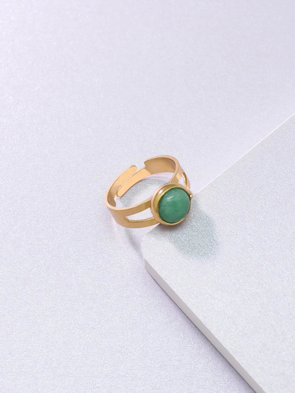Copper adjustable ring with green natural stone inlay and gold-toned plating on white background