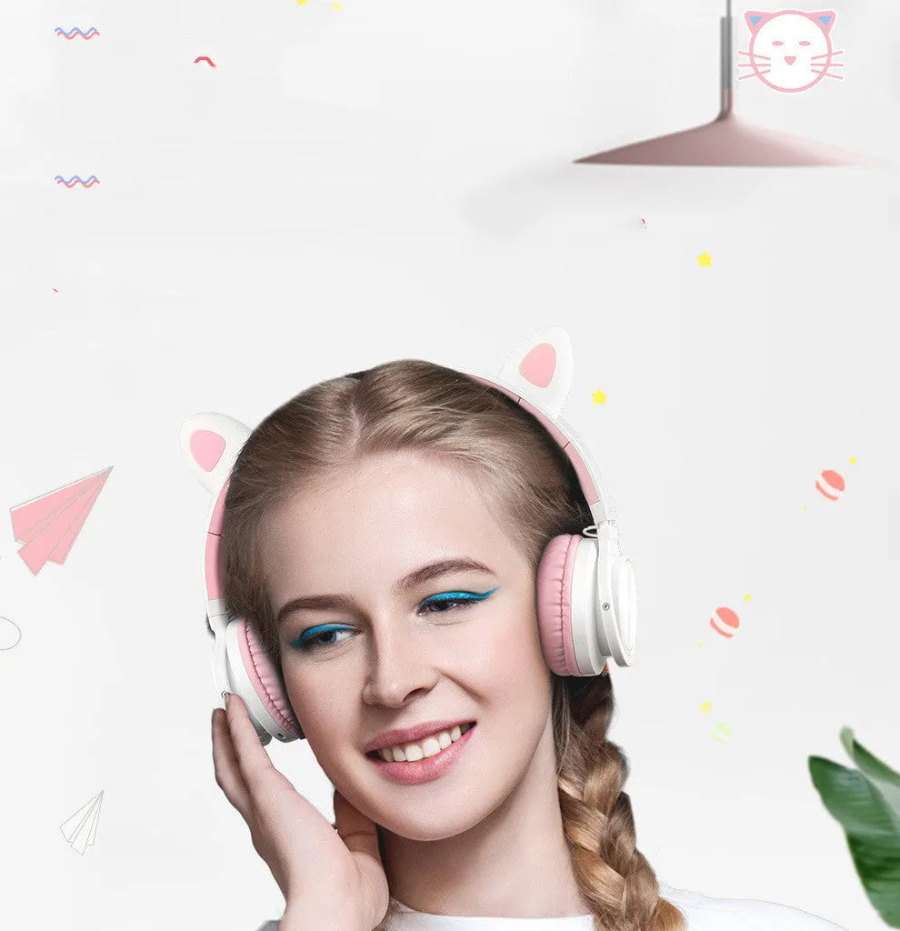 Pink and white Luminous Bluetooth wireless over-ear headset with microphone on a table.
