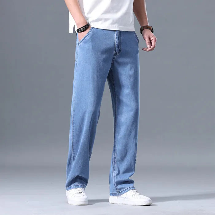 Men's light blue loose straight-leg lyocell jeans laid flat showing zip fly and relaxed fit