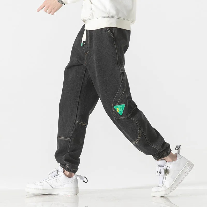 Men's loose-fit tapered cotton trousers in black showing tapered leg and mid-waist design