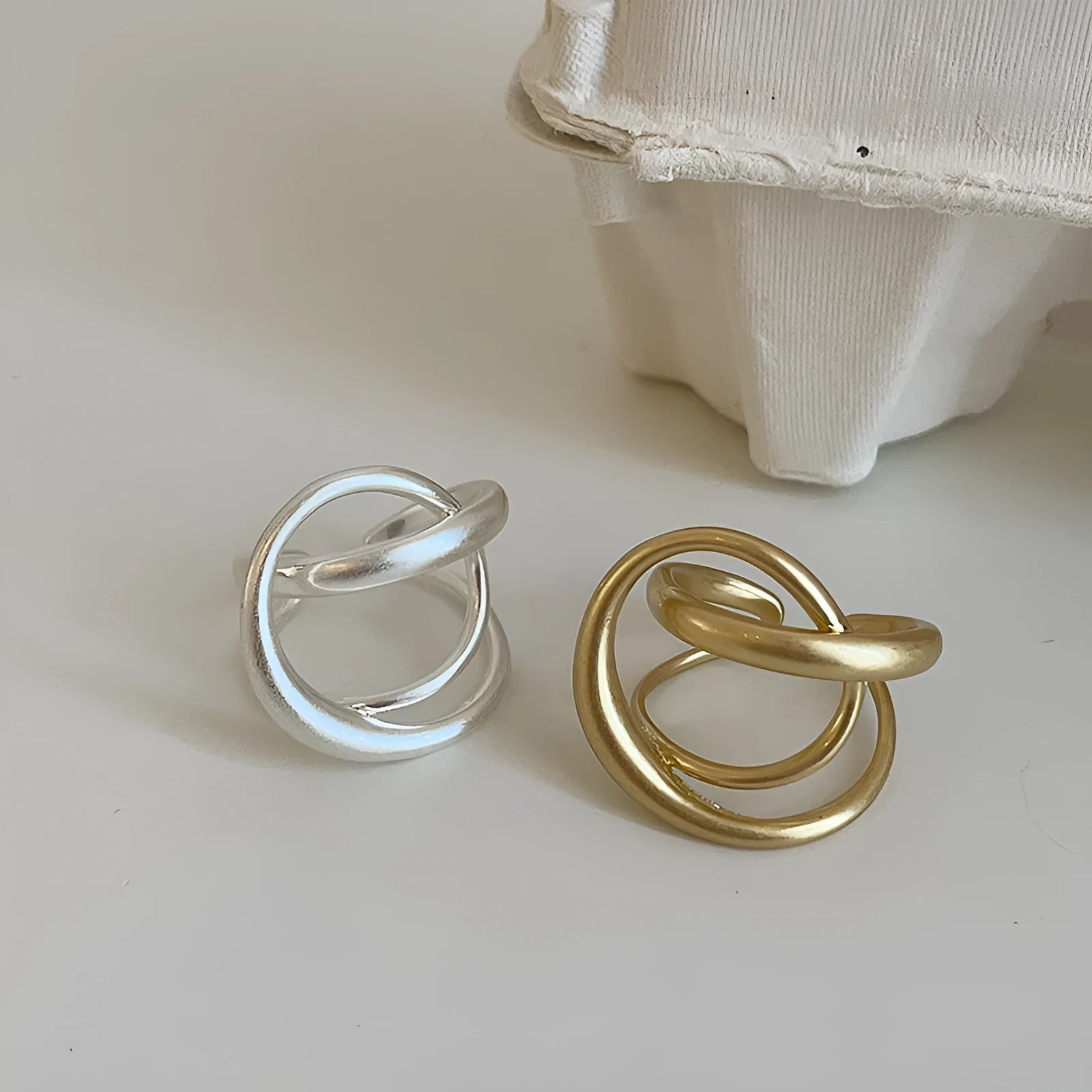 Geometric open ring with three-dimensional interlaced metal design in gold or silver colour