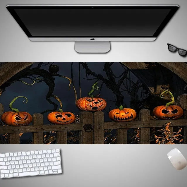Oversized Halloween graphic cloth mouse pad on a desk, showing non-slip rubber base.