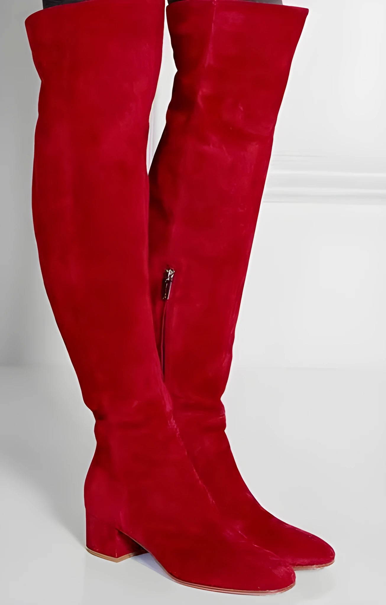 Women's grey suede over the knee flat boots with a low thick heel and pointed toe on a neutral background.