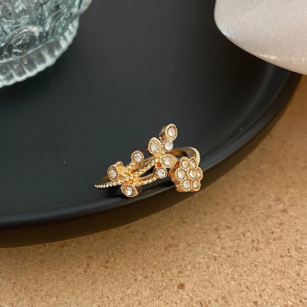 Copper open-ring with diamond-treated floral pattern and leaf details in gold colour