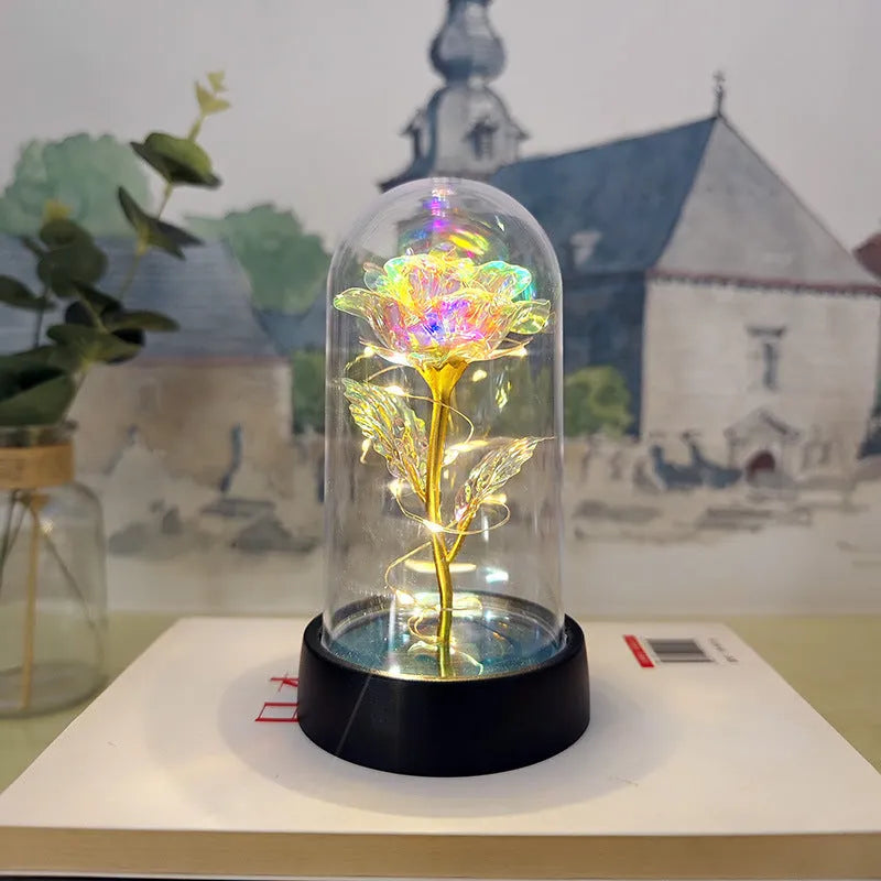 Small decorative night lamp with glass cover, plastic flower, and black base on a pink box.