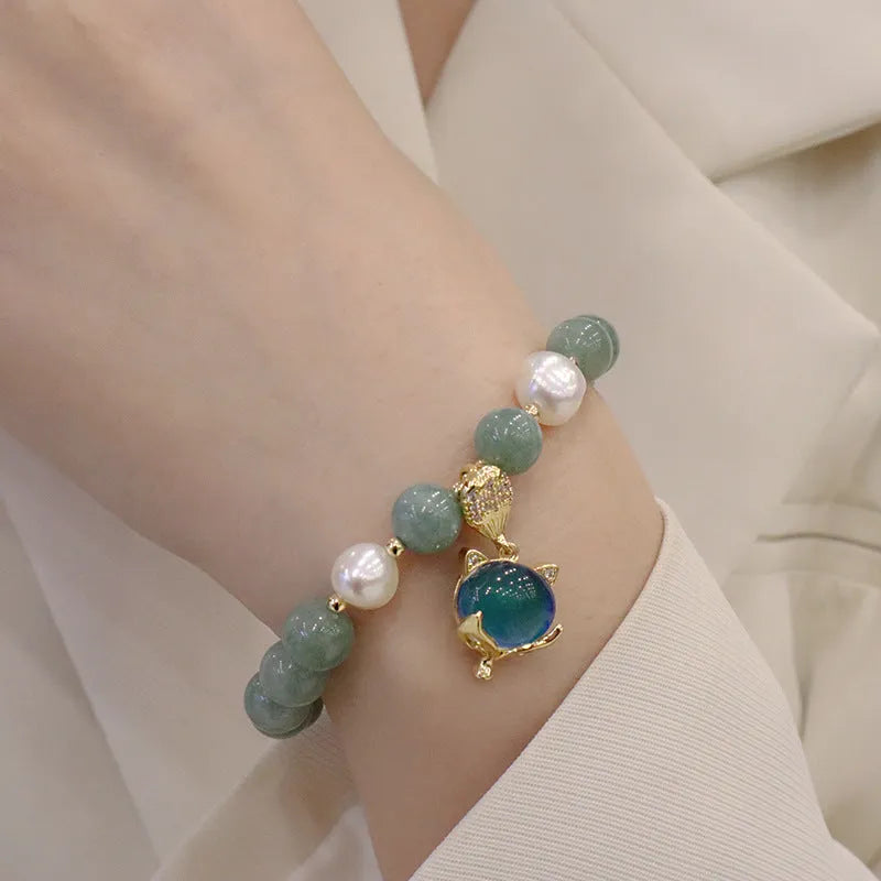 Burma jade warm fox pendant bracelet with temperature-sensitive feature and freshwater pearl accent on white background
