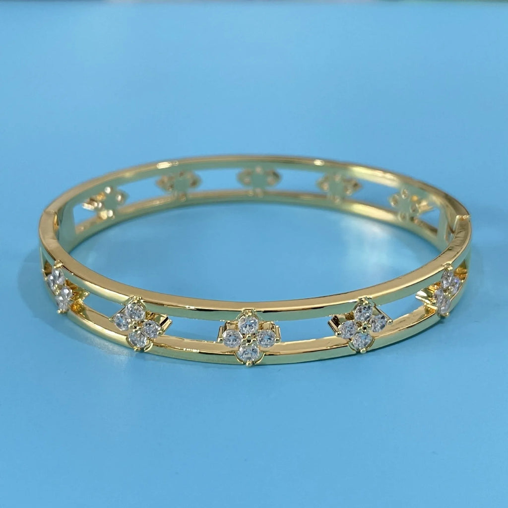 Women's hollow bracelet with zircon stones and four-leaf clover charm in gold and silver options