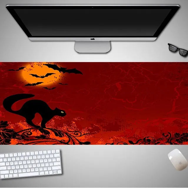 Oversized Halloween graphic cloth mouse pad on a desk, showing non-slip rubber base.