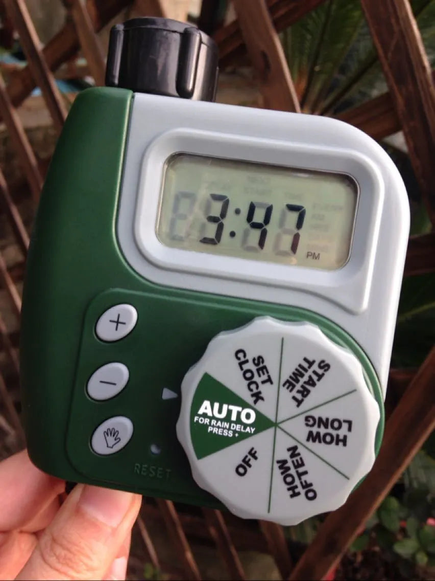 Green garden irrigation controller with LCD display and rotary dial for automatic hose timer
