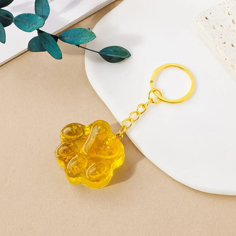 Small natural crystal cat's paw keychain pendant on a metal ring.