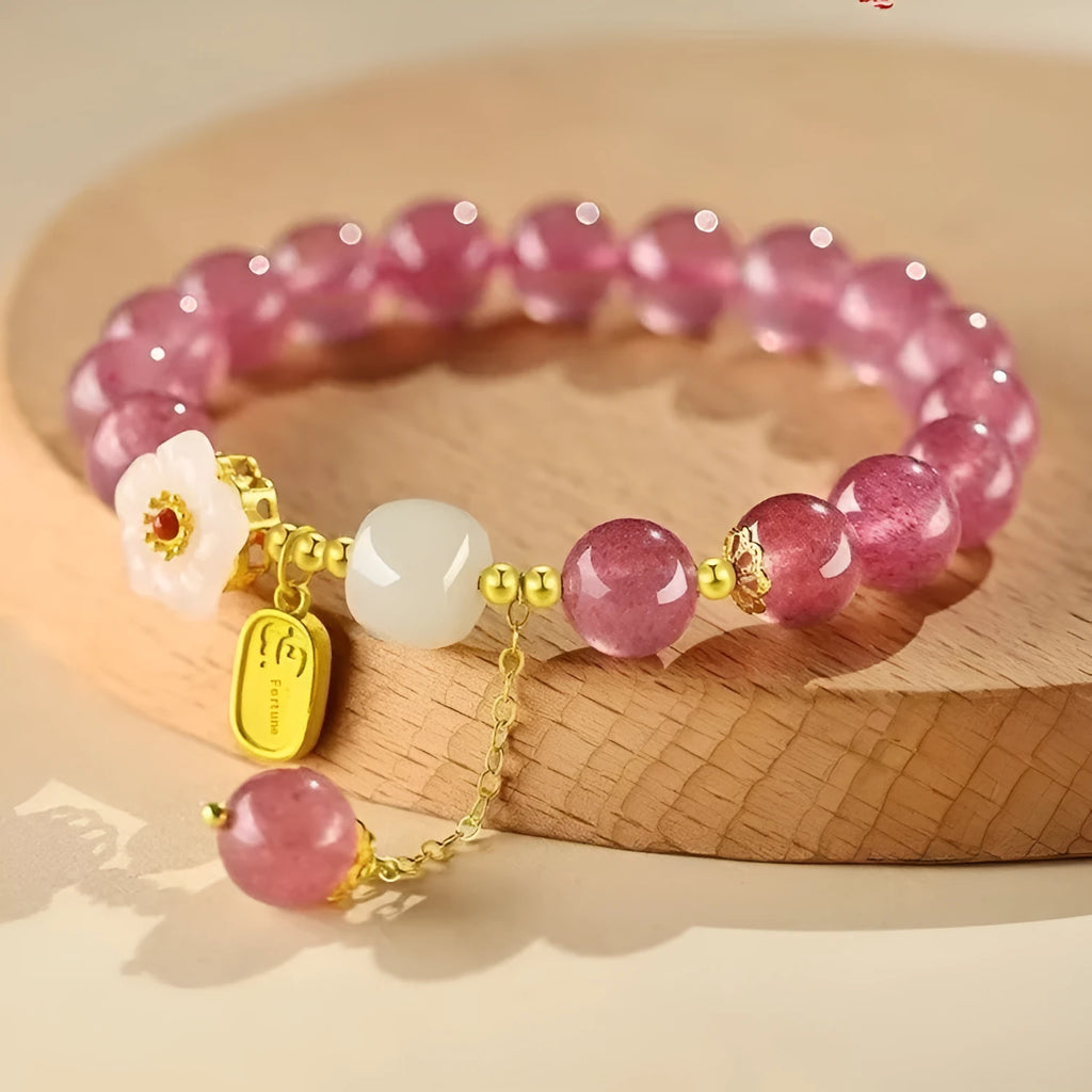 Handmade women's bracelet with strawberry quartz beads and Hetian jade peach blossom details.