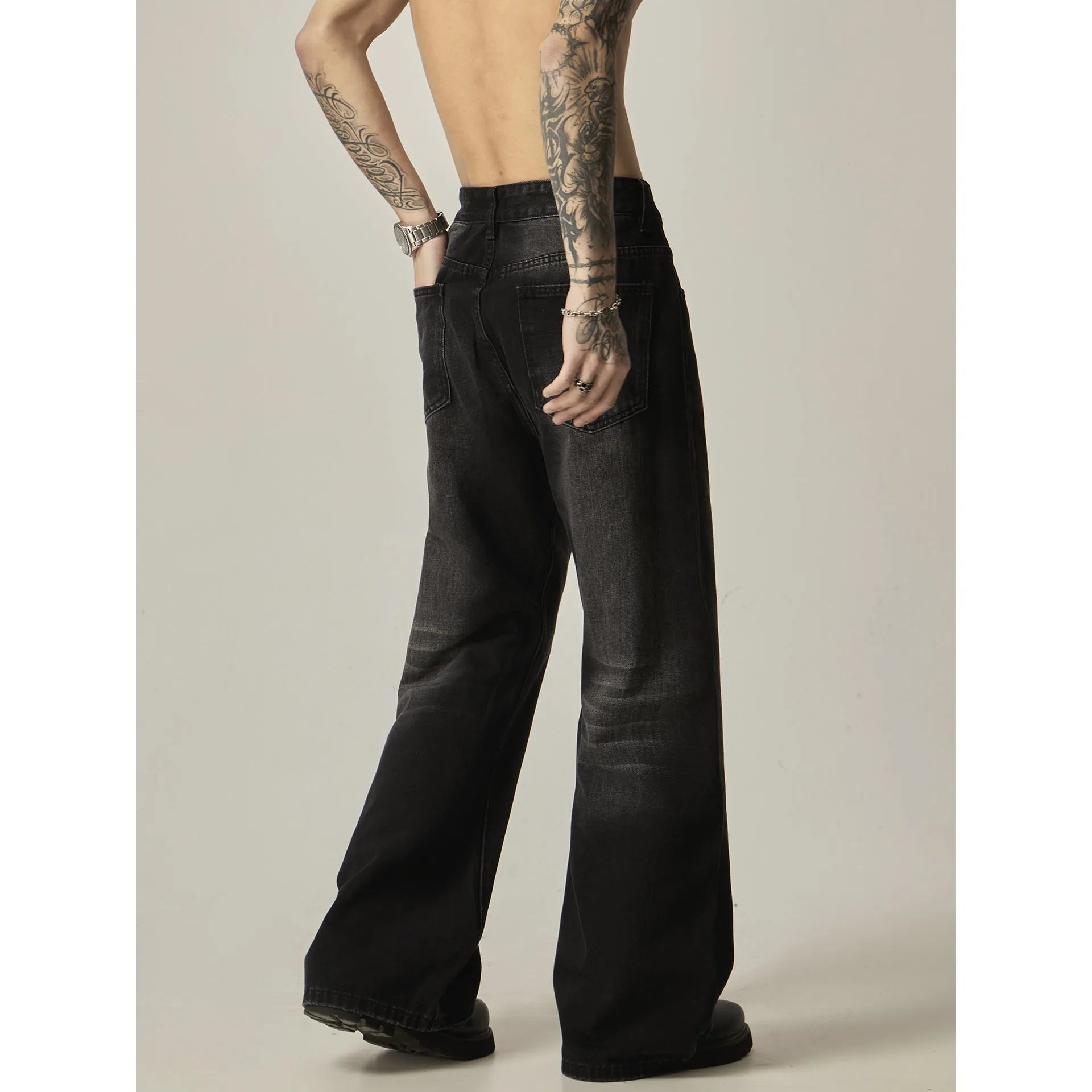 Black loose-fit straight-leg men's jeans with a zipper fly and retro styling.