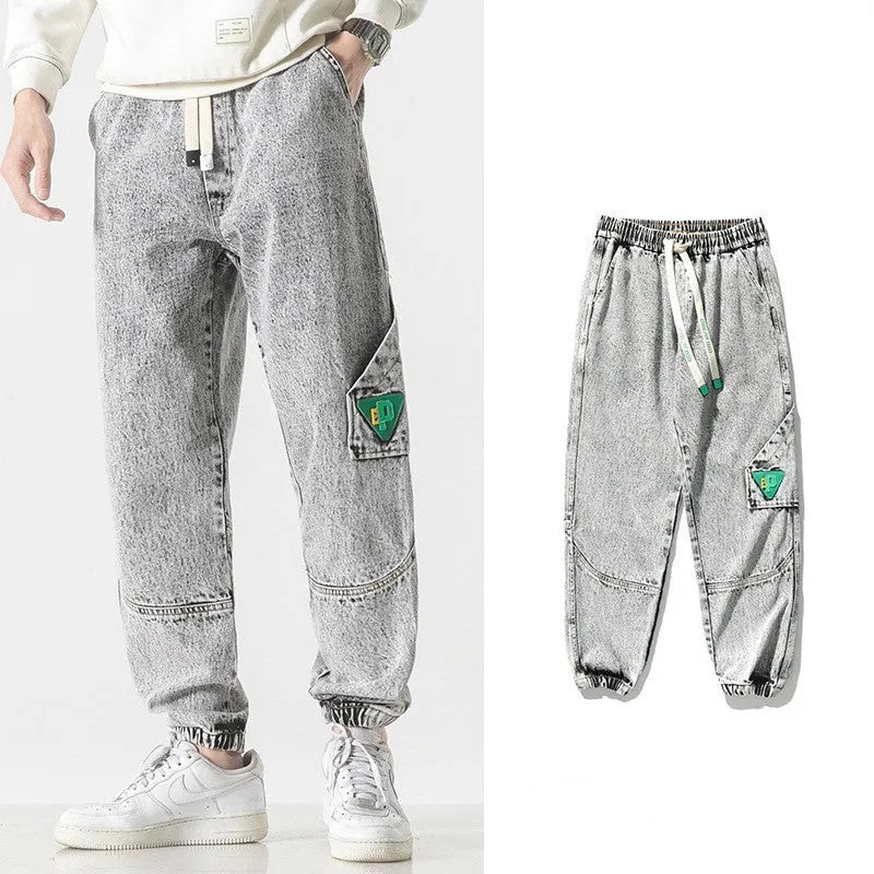 Men's loose-fit tapered cotton trousers in black showing tapered leg and mid-waist design