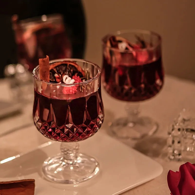 French mulled wine scented candle in a clear glass goblet on a table