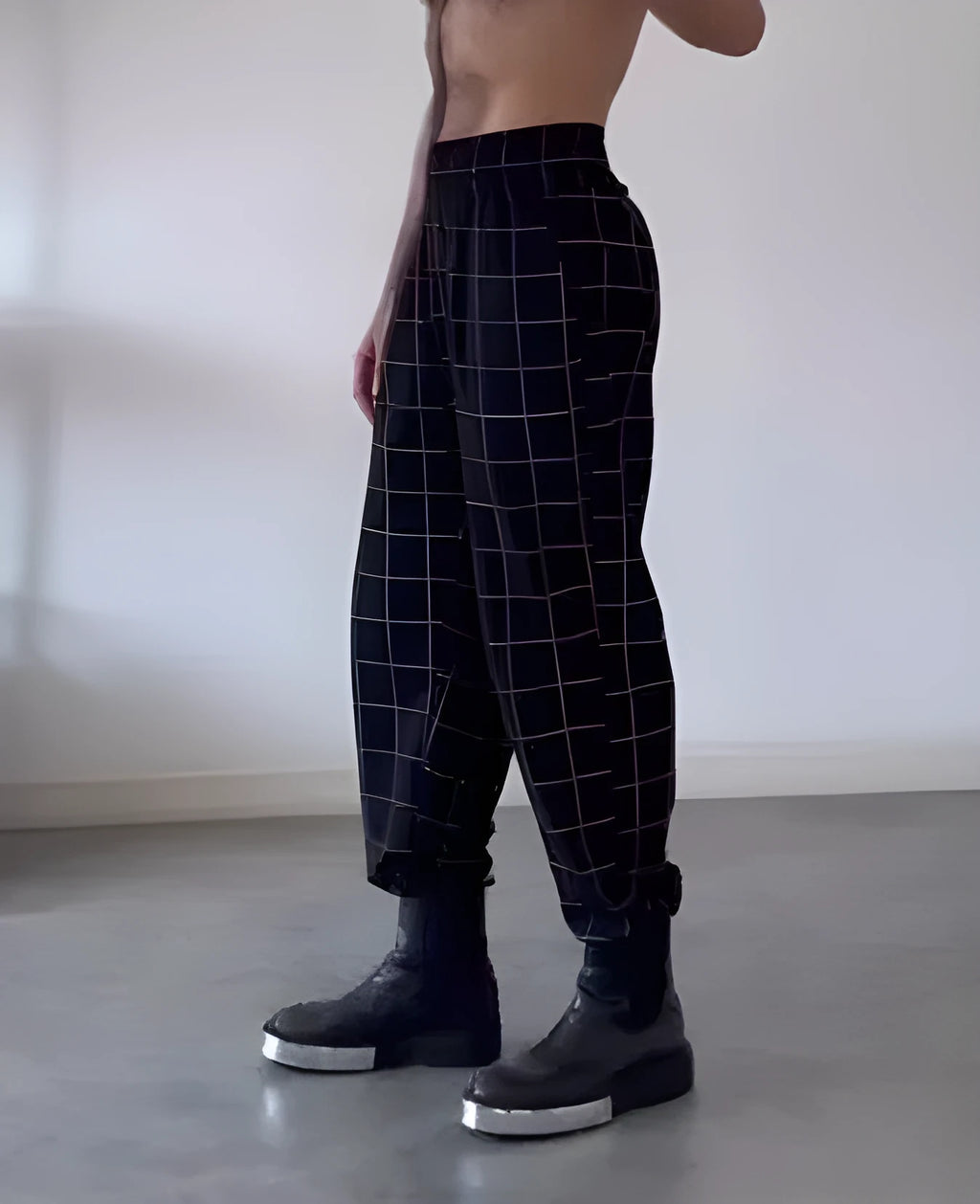 Men's plaid trousers with apron feature showing adjustable waistband and pocket details