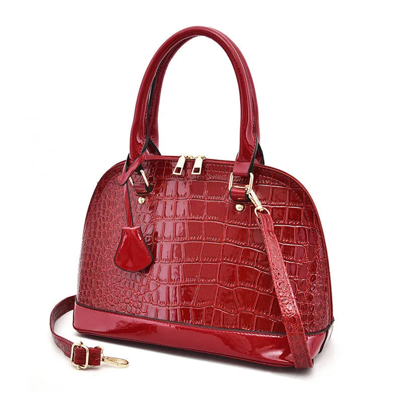 Shiny black PU crossbody bag showing structured shell shape and dimensions