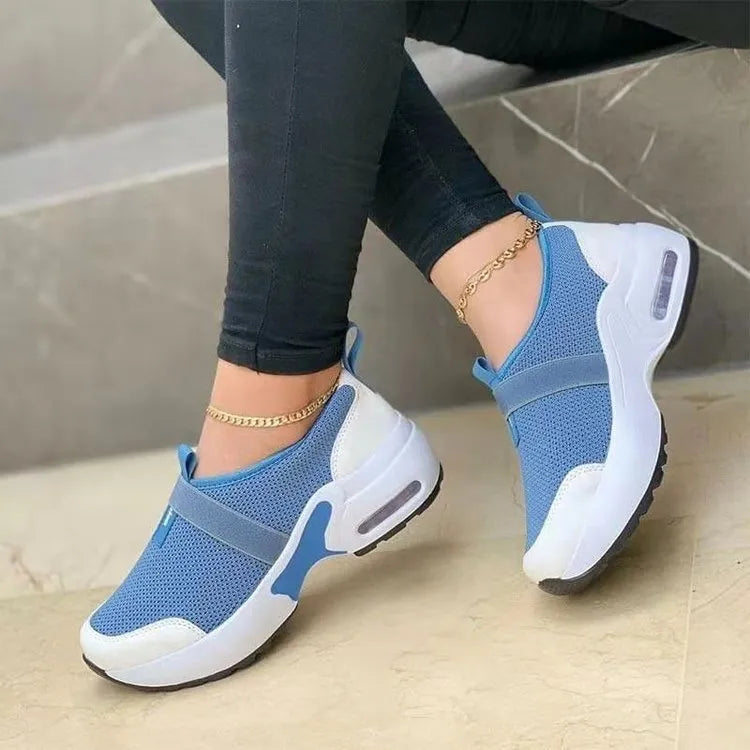 Women's white mesh flat sneakers with round toe and colour stitching on a rubber sole.