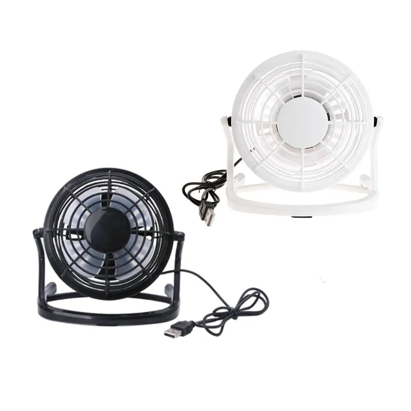 Mini black USB desk fan with adjustable head on a wooden desk next to a laptop.