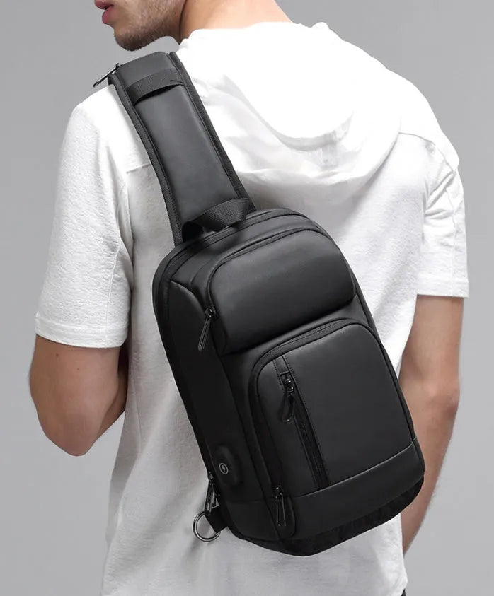 Black medium-sized PVC outdoor shoulder bag with a single strap and internal organiser pockets.
