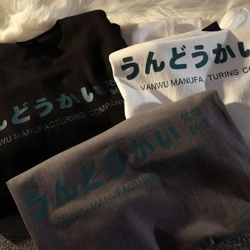 A loose-fitting black cotton t-shirt with a white letter print, shown on a hanger.