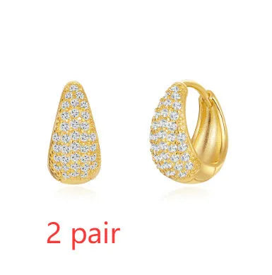 Golden brass earclip earrings with geometric shapes and round elements