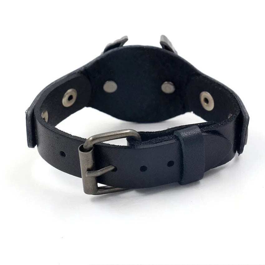 Black leather bracelet with an alloy eagle decoration and watch-button clasp on a wrist.