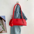 Crossbody shoulder bag in black PU with double straps, horizontal square shape, and visible sewing thread detail on front