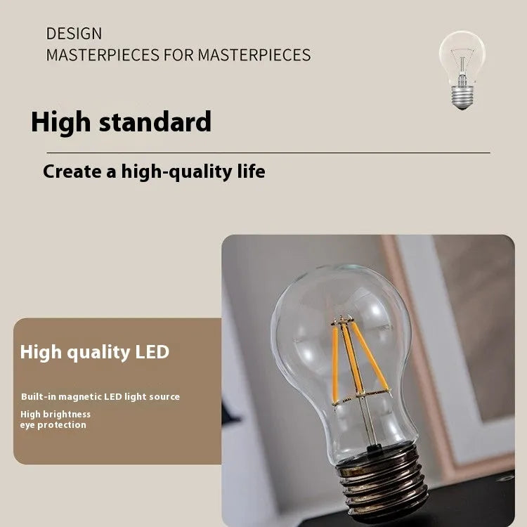 Creative iron art night lamp with a suspended bulb on a black wood grain base.