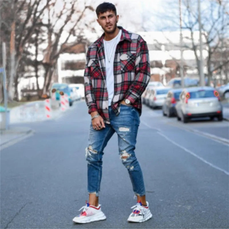 Men's blue jeans with hole detailing showing cotton fabric texture and distressed design