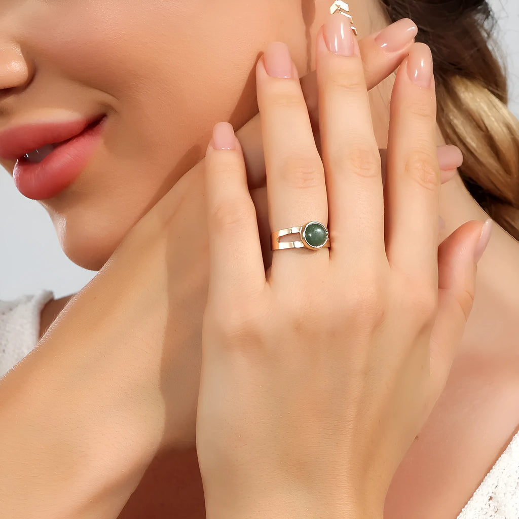 Copper adjustable ring with green natural stone inlay and gold-toned plating on white background