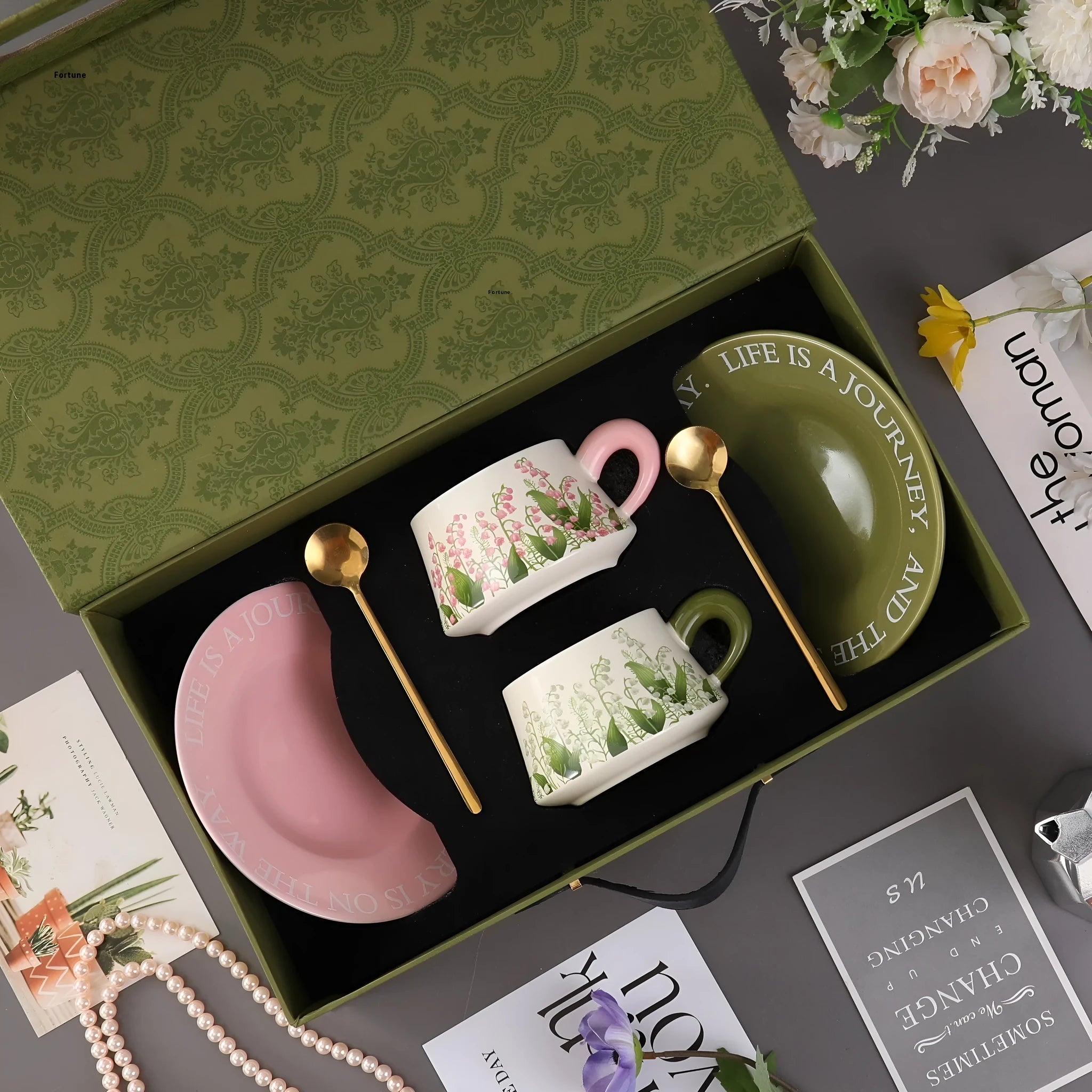 Ceramic coffee cup and saucer set for two with matching spoons in bell-shaped design