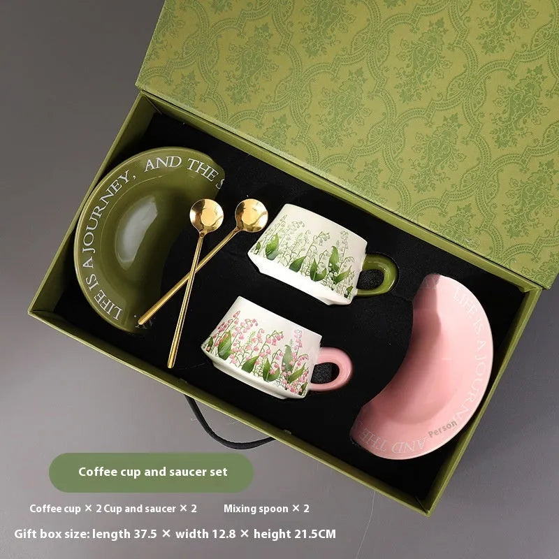 Ceramic coffee cup and saucer set for two with matching spoons in bell-shaped design