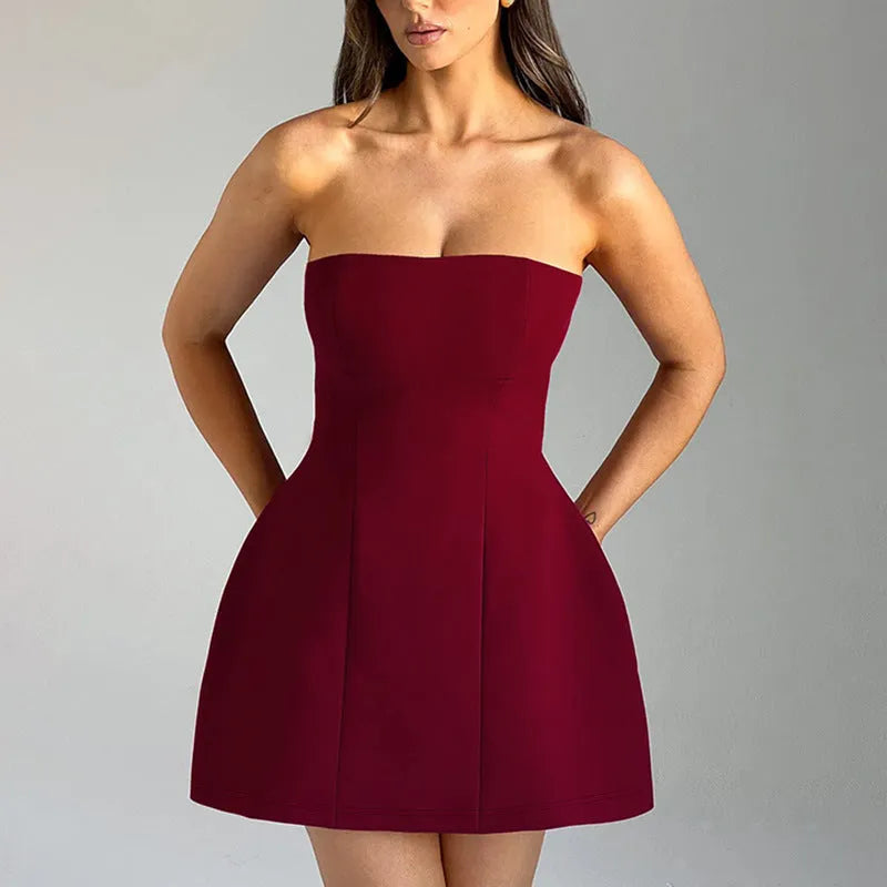 A woman wearing a solid colour backless A-line tube dress with a high waist and short skirt.