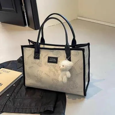 Women's black canvas tote bag with diamond pattern and shoulder strap