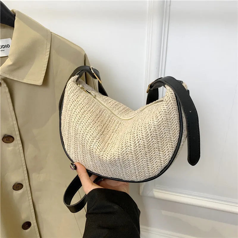 Women's knitted straw woven crossbody bag showing woven texture and internal phone compartment