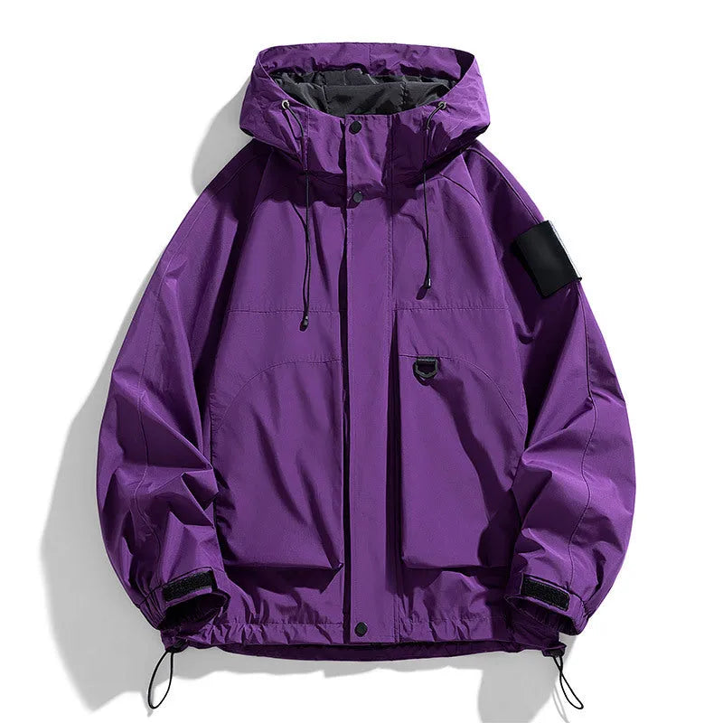 Man wearing a black hooded waterproof windproof jacket with long sleeves.