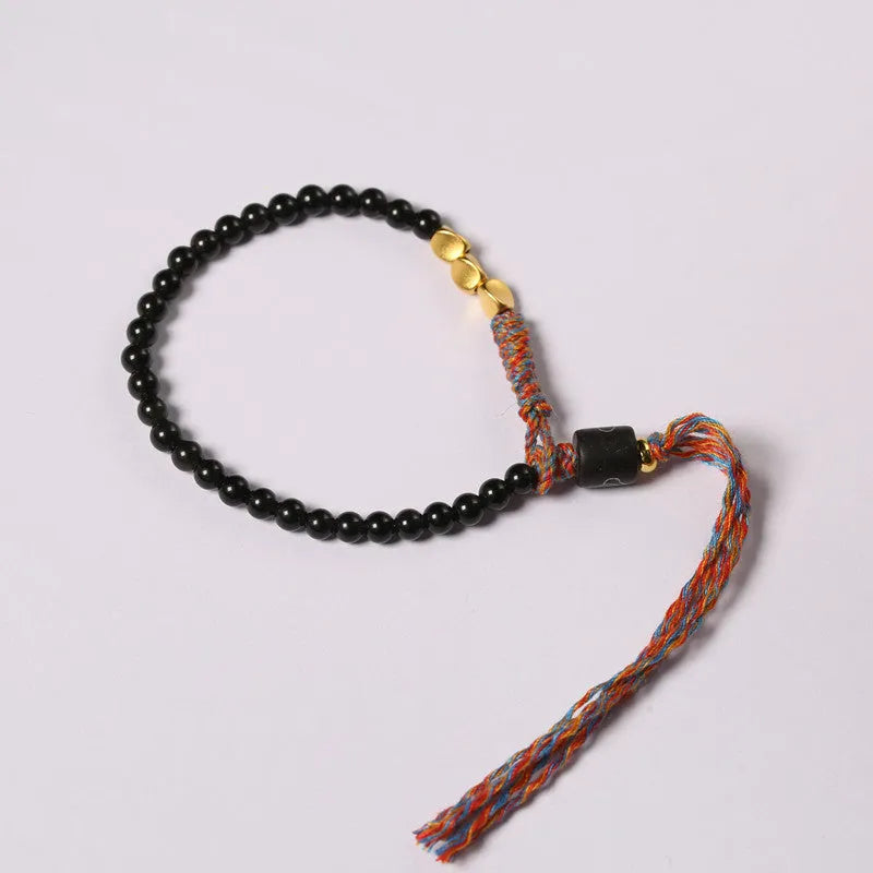 Hand-woven obsidian carrying strap bracelet showing textured weave detail and narrow 4mm width